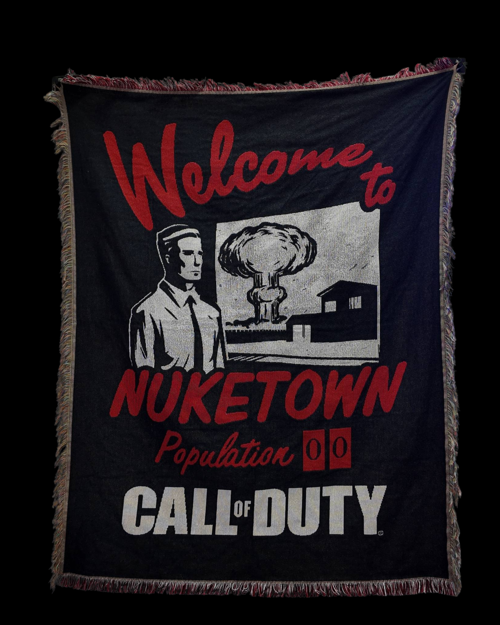 Wall tapestry with “Welcome to Nuketown – Population 00” and “Call of Duty” text, featuring a black-and-white illustration of a man and a nuclear explosion in the background on a dark fabric with red lettering.